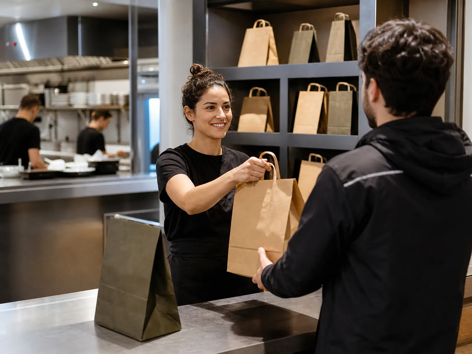 Professionnelle remettant une commande à un coursier