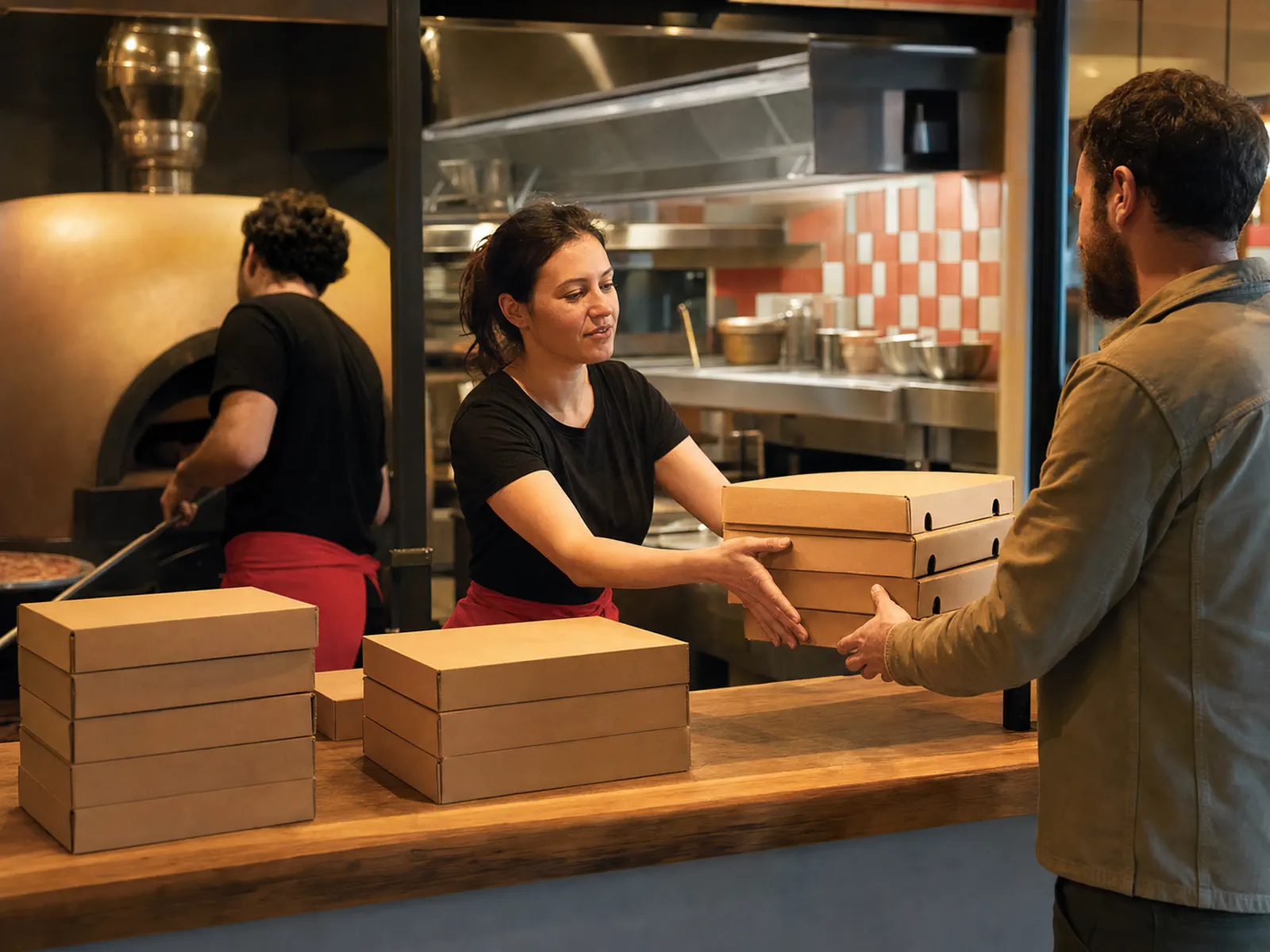 Équipière remettant des commandes à emporter au comptoir
