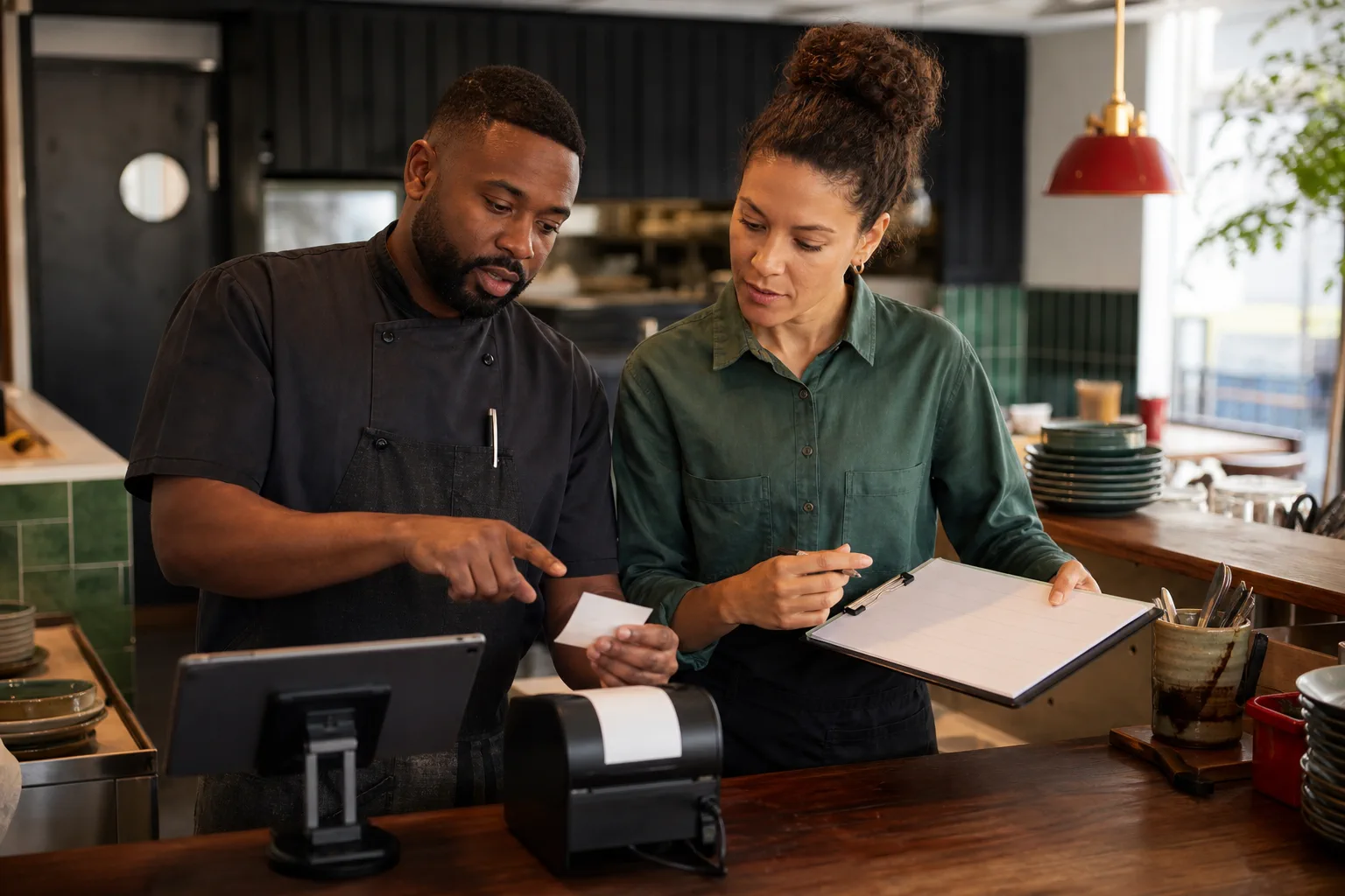 Équipe de restaurant préparant un signalement avec une tablette et une imprimante